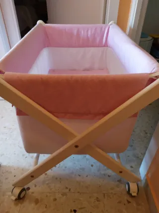 Minicuna con ruedas y vestidura rosa