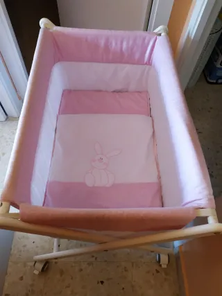 Minicuna con ruedas y vestidura rosa