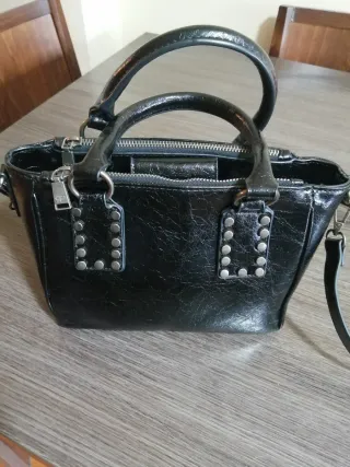 Bolso de mano negro con tachuelas