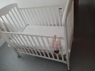 Cuna de bebé blanca con ruedas