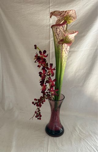 Jarrón con flores artificiales moradas y rojas