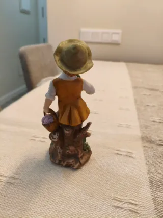 Figura niño recogiendo uvas