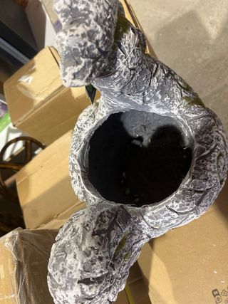 Portavasi in pietra grigia e bianca a forma di gallina