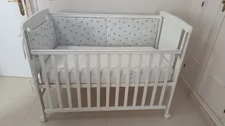 Cuna blanca con colchón de triple funda.