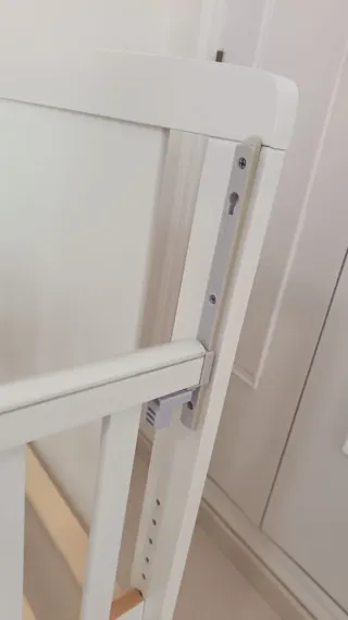 Cuna blanca con colchón de triple funda.