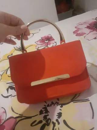 Bolso rojo con asa dorada
