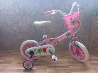 Bicicleta infantil rosa con cesta y ruedines