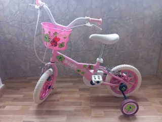 Bicicleta infantil rosa con cesta y ruedines