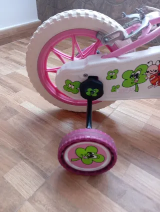 Bicicleta infantil rosa con cesta y ruedines