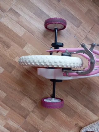 Bicicleta infantil rosa con cesta y ruedines