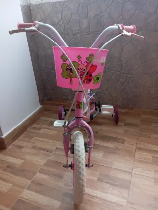 Bicicleta infantil rosa con cesta y ruedines