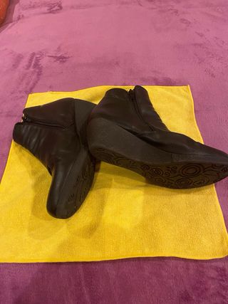 Botines de piel negra con tacón cuña.