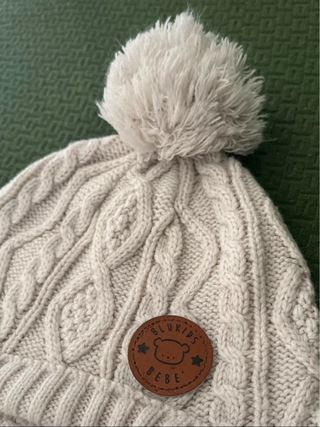 Berretto bimbo panna con pon pon e lacci