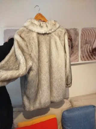Abrigo de piel sintética blanco y gris.