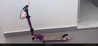 Patinete morado con ruedas naranjas