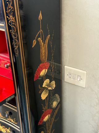 Cómoda antigua negra con detalles dorados