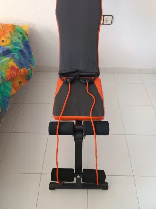 Banco de pesas ajustable naranja y negro.