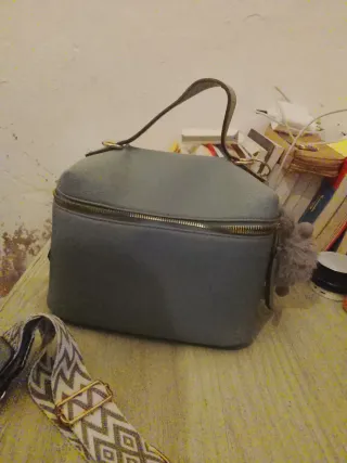 Maletín de maquillaje gris con detalles dorados