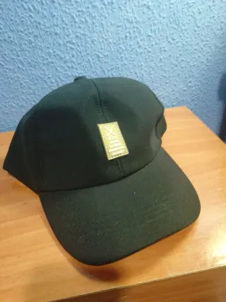 Gorra de golf negra con detalle dorado