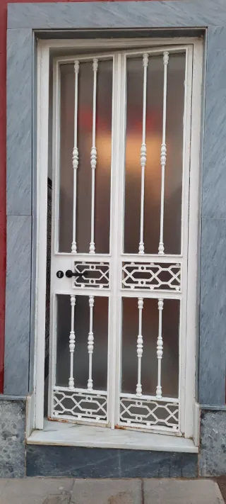 Puerta de hierro forjado con cristal antigua