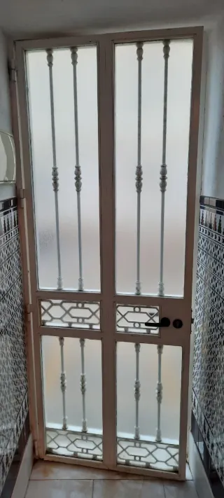 Puerta de hierro forjado con cristal antigua