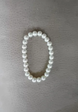 Pulseras de perlas blancas.