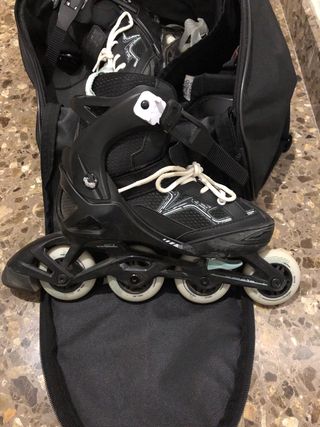 Patines en línea negros con bolsa y rodilleras.