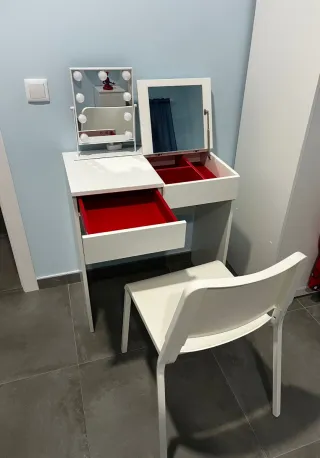 Tocador con espejo, cajones y silla.