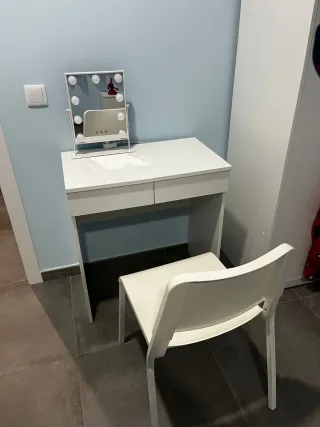 Tocador con espejo, cajones y silla.