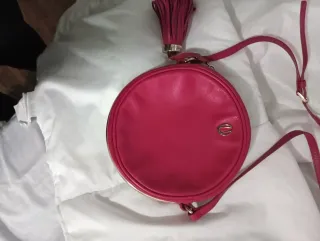 Bolso Uterqüe redondo color fucsia y ribete dorado