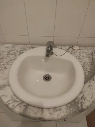 Mueble de baño blanco con espejo y grifo