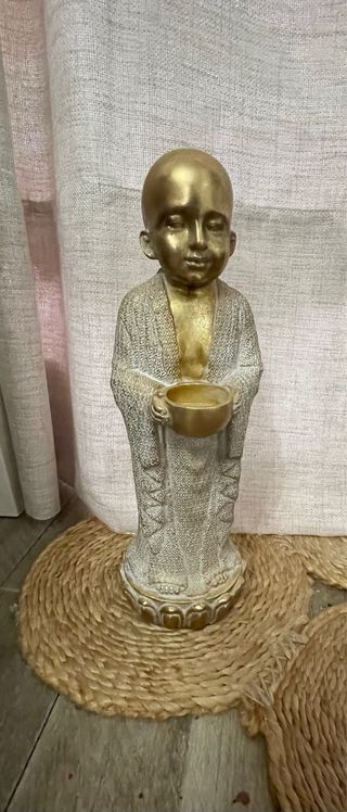 Scultura in pietra beige e dorata del Buddha