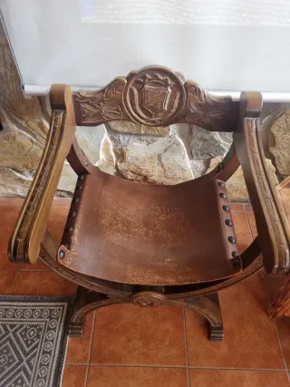 Sillón de madera y cuero con escudo