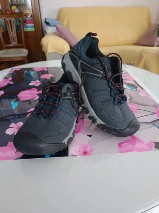 Zapatillas de montaña azul marino y rojas.