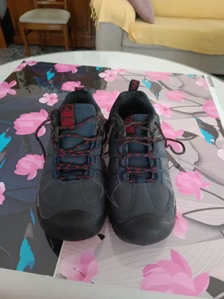 Zapatillas de montaña azul marino y rojas.