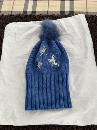 Gorro de punto azul con estrellas plateadas
