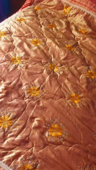 Colcha naranja con bordado floral