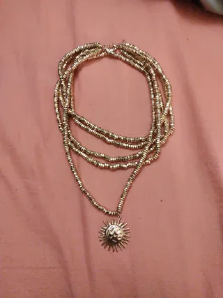 Collar de cuentas dorado con colgante de sol