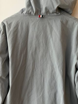 Chaqueta gris azulada con cremallera blanca