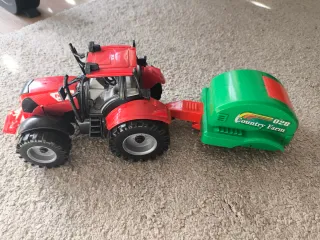 Tractor rojo con remolque verde