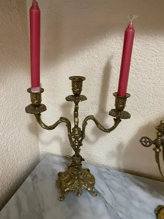 Coppia di candelabri dorati con candele rosse