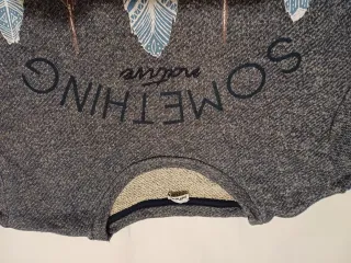 Sudadera gris con estampado de plumas