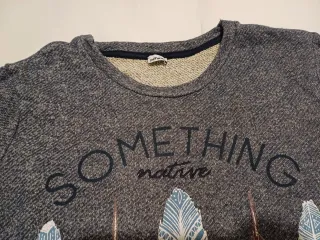 Sudadera gris con estampado de plumas