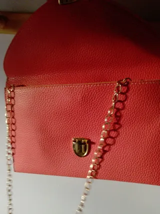 Bolso de mano rosa con cadena dorada
