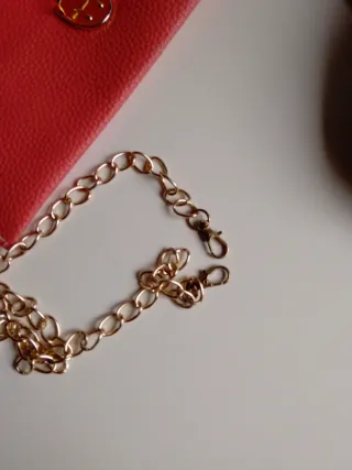 Bolso de mano rosa con cadena dorada