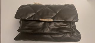 Bolso negro acolchado con cadena dorada