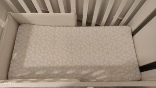 Cuna de bebé blanca con diseño de dinosaurio