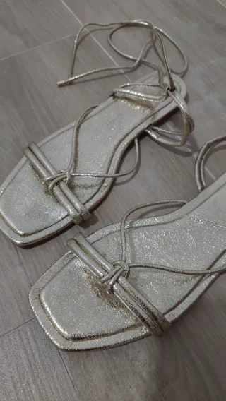 Sandalias doradas atadas en tobillo