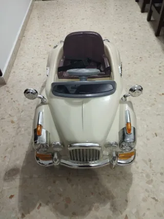 Coche eléctrico para niños, color beige.