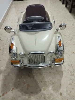 Coche eléctrico para niños, color beige.